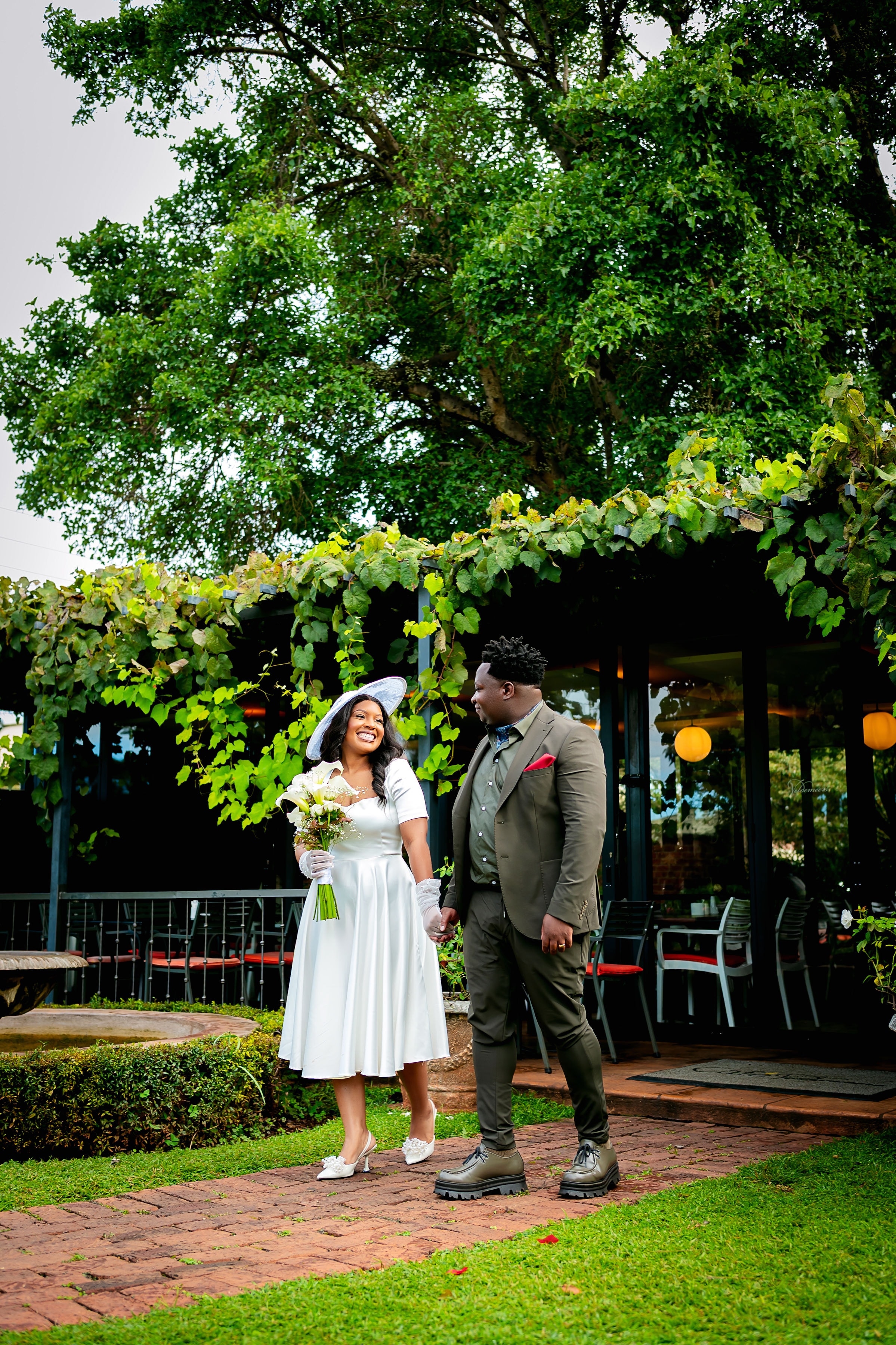 Wedding couple walking hand in hand through a garden